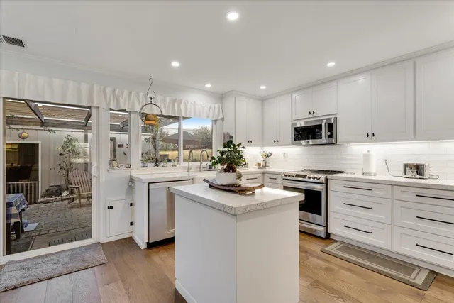 a kitchen with white cabinets and stainless steel appliances