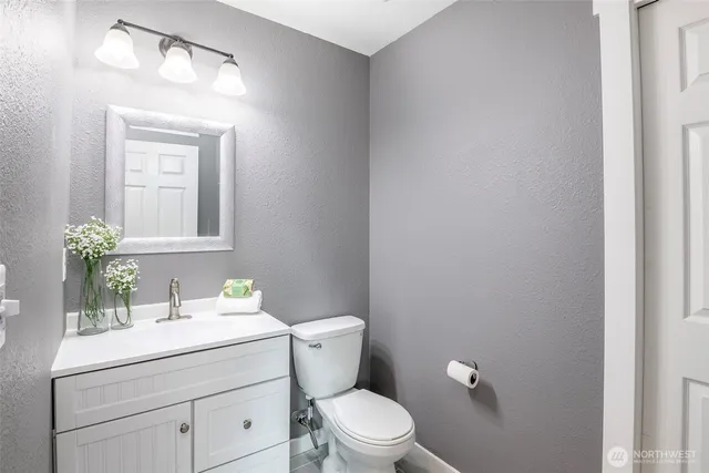 a bathroom with a toilet a sink and mirror