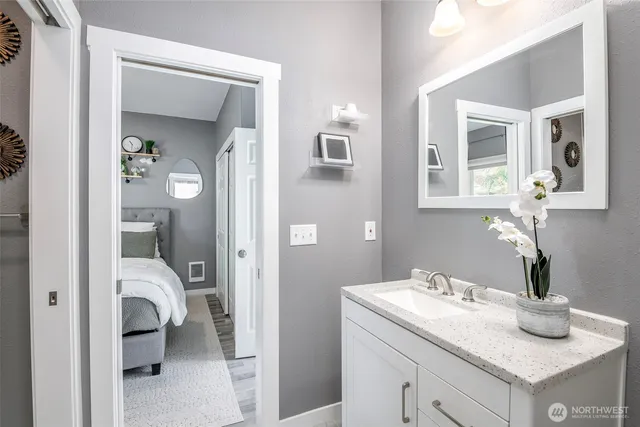 a en suite bathroom with a granite countertop sink and a mirror