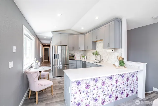 a kitchen with granite countertop kitchen island stainless steel appliances a sink and a refrigerator