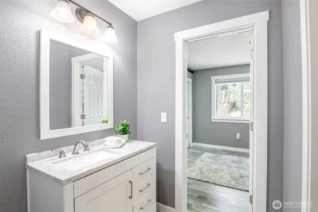 a bathroom with a sink vanity and mirror