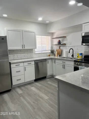 a kitchen with a sink white cabinets and white appliances
