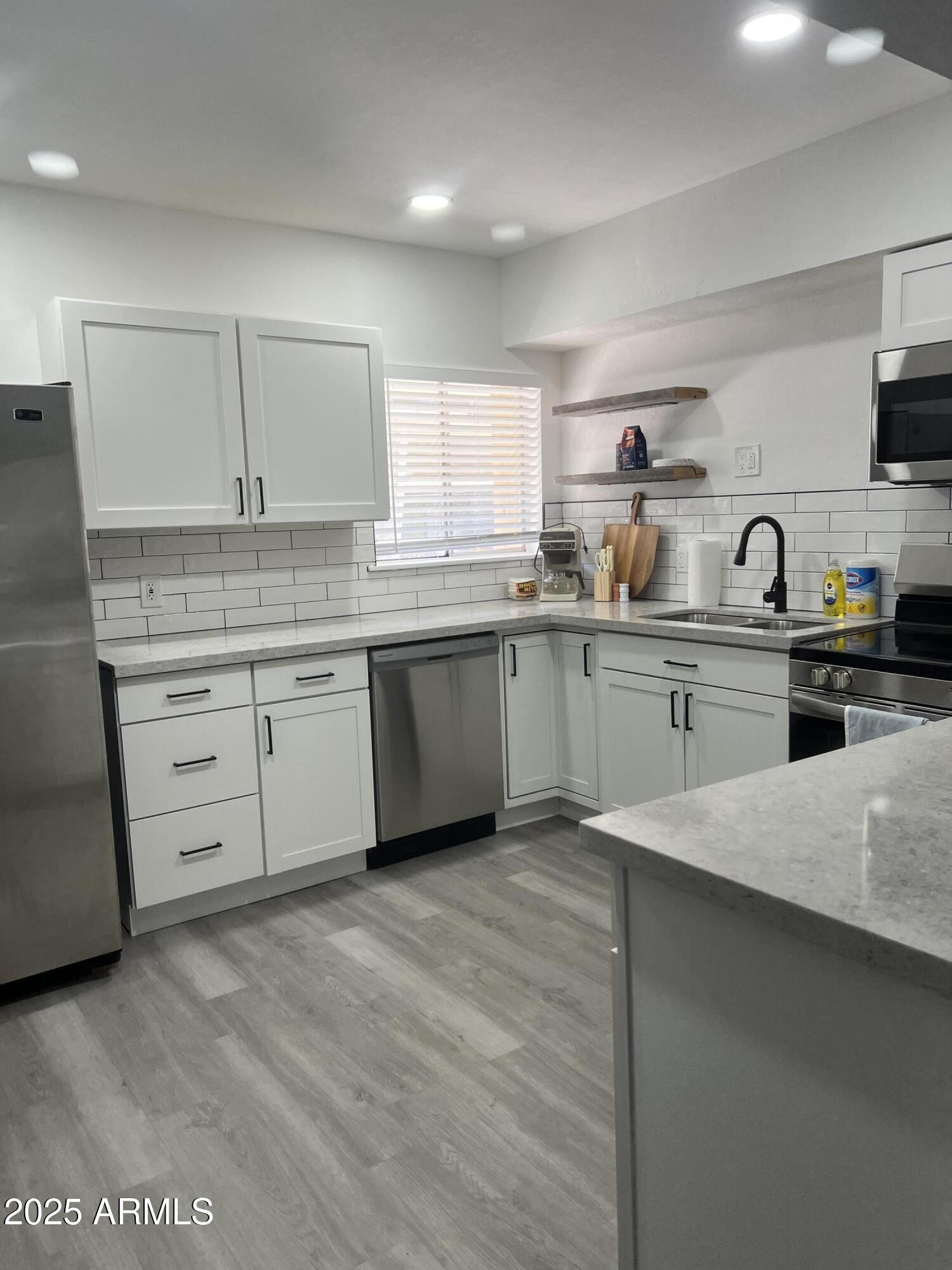 a kitchen with a sink white cabinets and white appliances