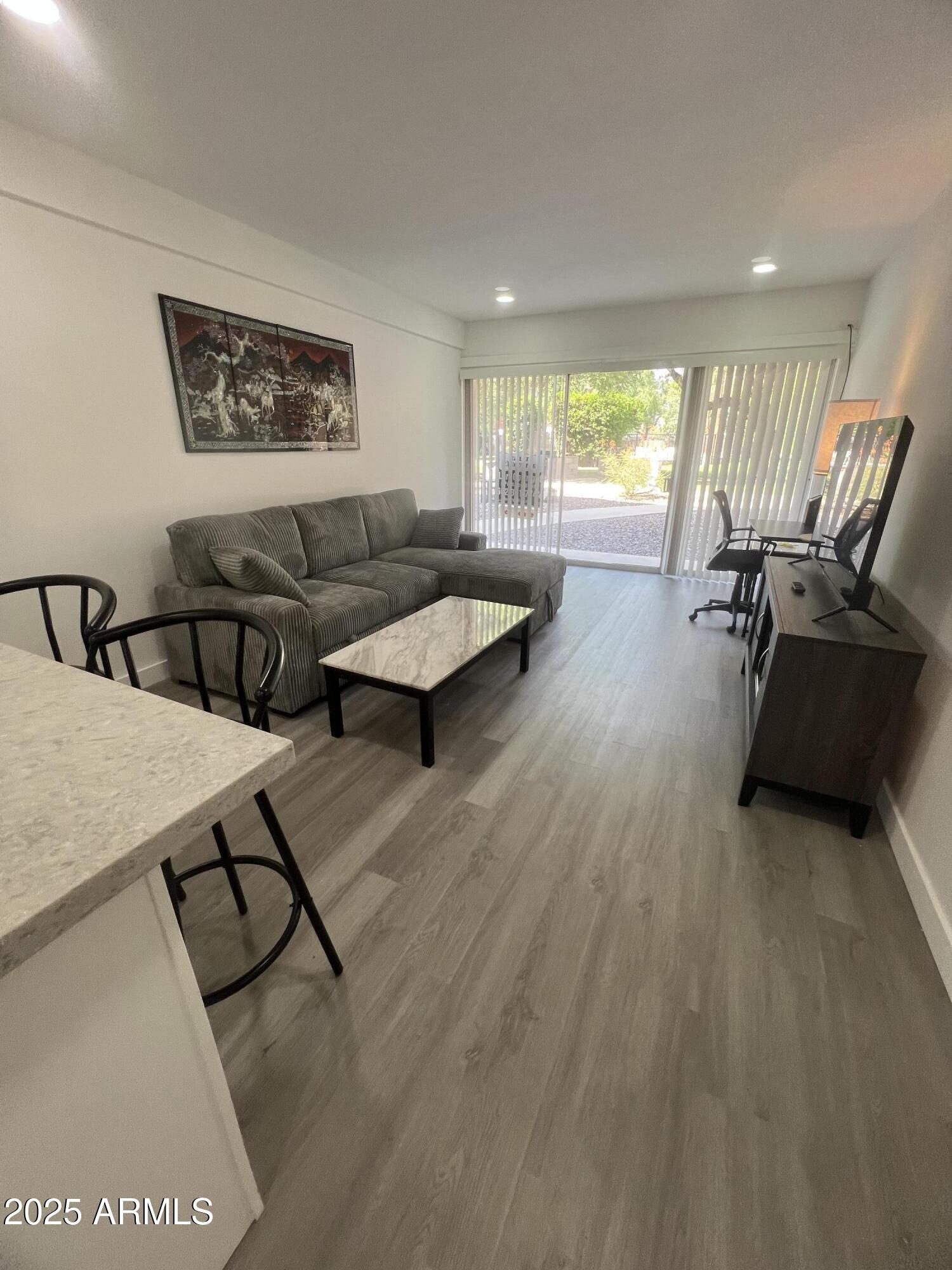 353 East Thomas Road, Unit C104 Phoenix, AZ 85012 - Photo 13 of 17 a living room with furniture and wooden floor