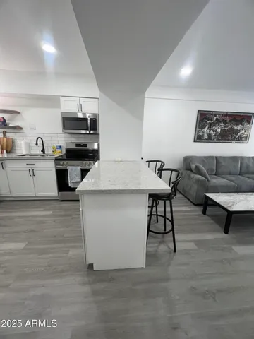 a living room with stainless steel appliances kitchen island granite countertop furniture and a kitchen view