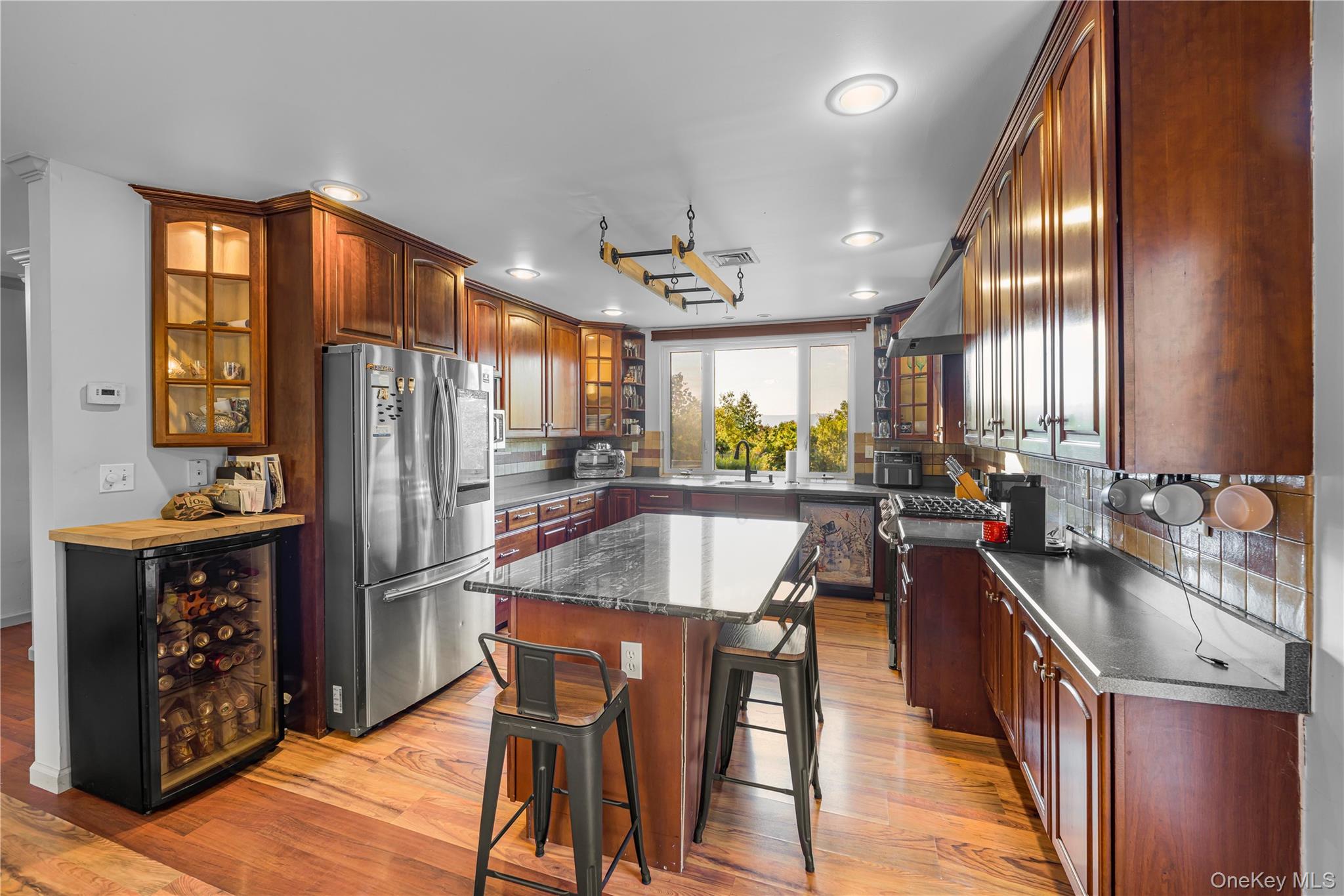 17 Brendella Court Wallkill, NY 12589 - Photo 6 of 39 Kitchen with appliances with stainless steel finishes, glass insert cabinets, light wood-style floors, decorative backsplash, and recessed lighting