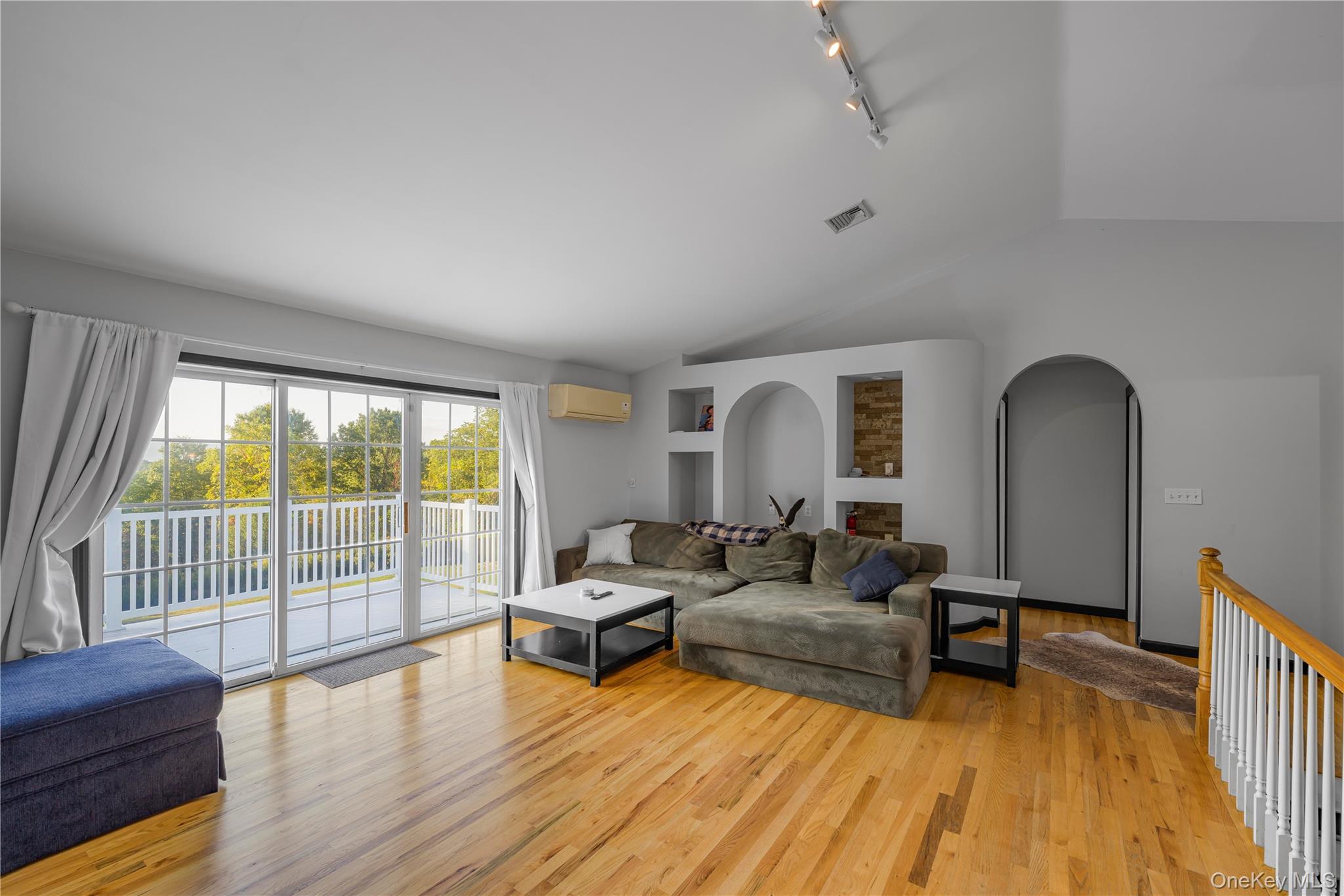 17 Brendella Court Wallkill, NY 12589 - Photo 9 of 39 Living area with light wood-type flooring, lofted ceiling, rail lighting, and an AC wall unit