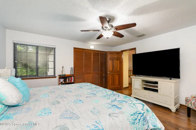 a bedroom with a bed and a flat screen tv