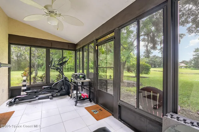 a room with gym equipment and large windows
