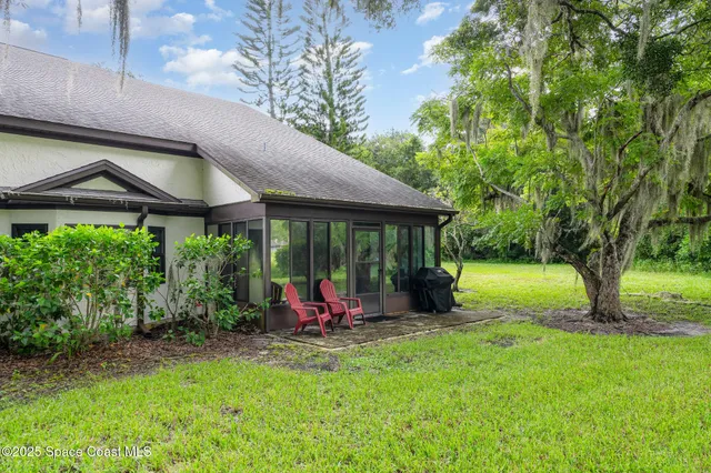 a view of a house with a big yard and large tree