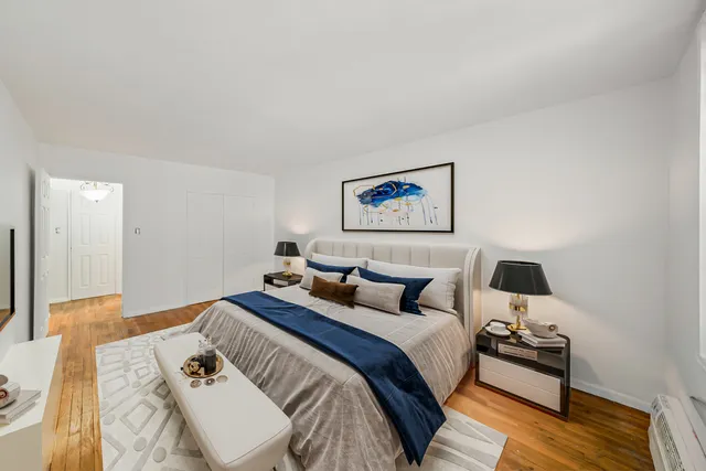 a bedroom with a bed and wooden floor