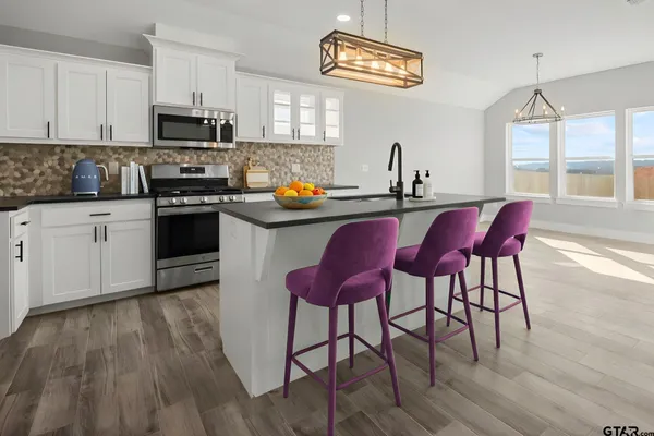 a kitchen with cabinets wooden floor and a window