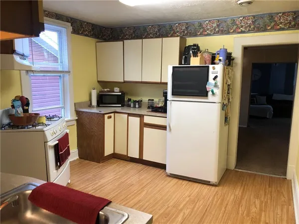a kitchen with stainless steel appliances kitchen island granite countertop a refrigerator a stove a sink and dishwasher with wooden floor