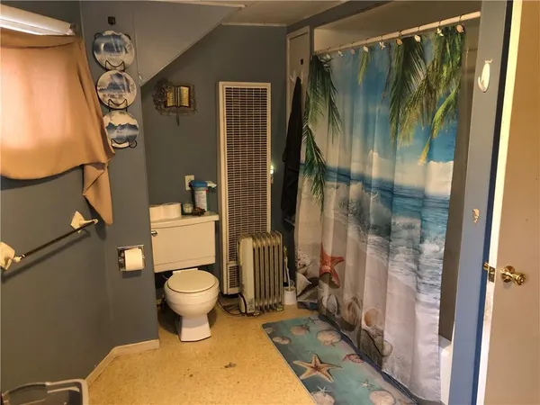 a bathroom with a toilet and a shower