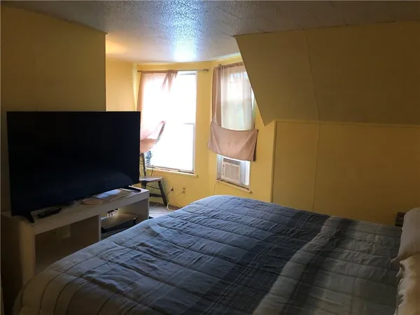 a bedroom with two beds and a flat screen tv