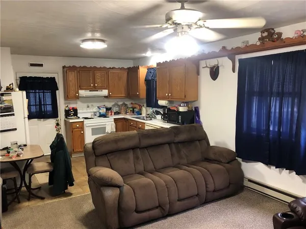 a living room with furniture a chandelier and kitchen view