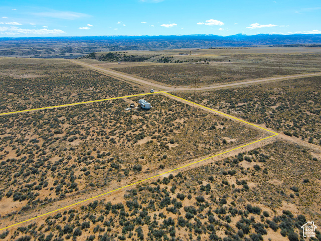 6000 South Well Road East, Unit 6 Duchesne, UT 84021 - Photo 9 of 12 Aerial view of sparsely populated area featuring property parcel outlined and a mountainous background