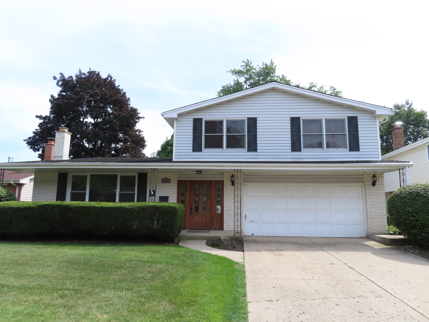 169 Sunrise Drive Wheeling, IL 60090 - Photo 2 of 5 a front view of a house with a yard and potted plants