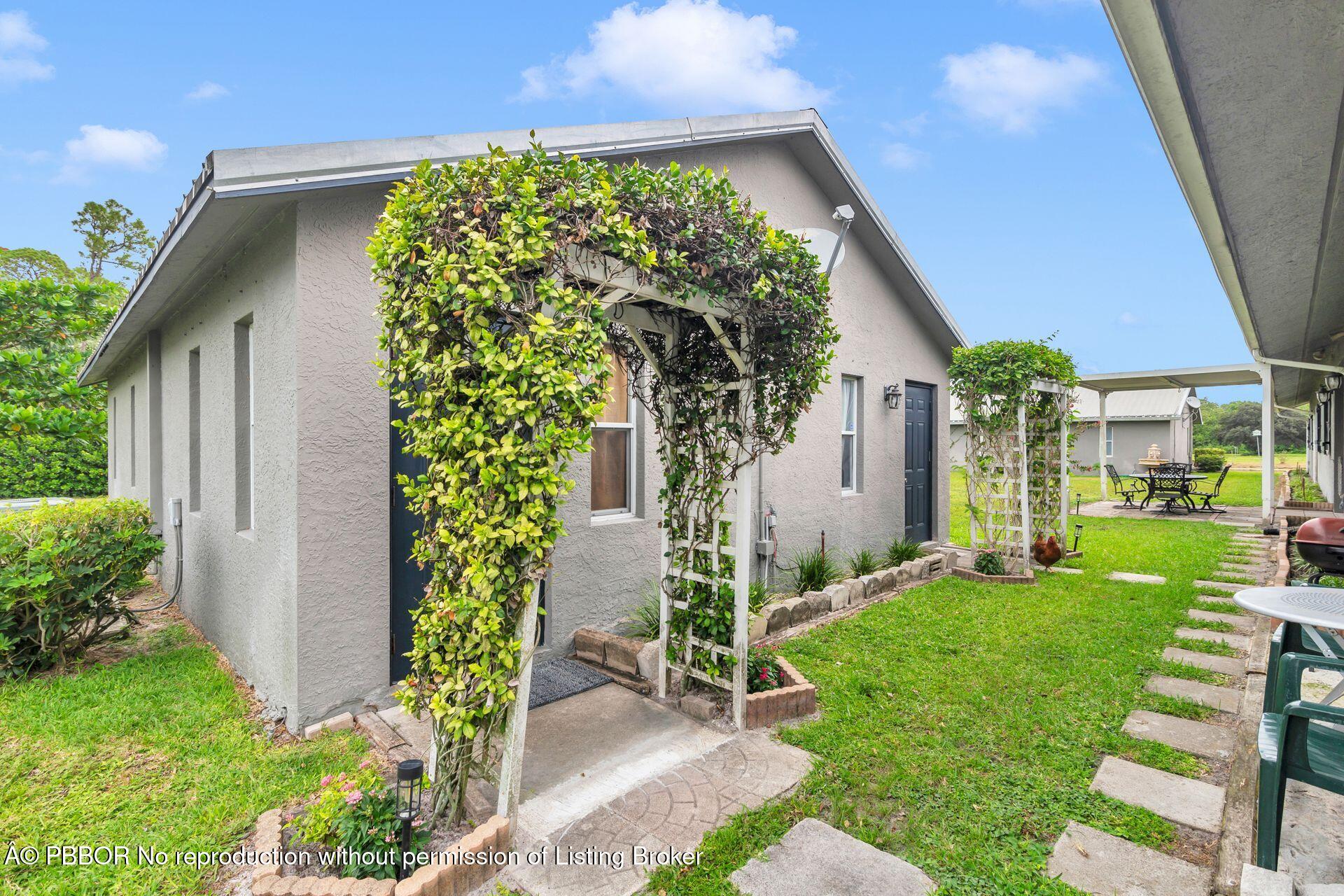 2770 E Road Loxahatchee, FL 33470 - Photo 27 of 51 a front view of a house with a yard