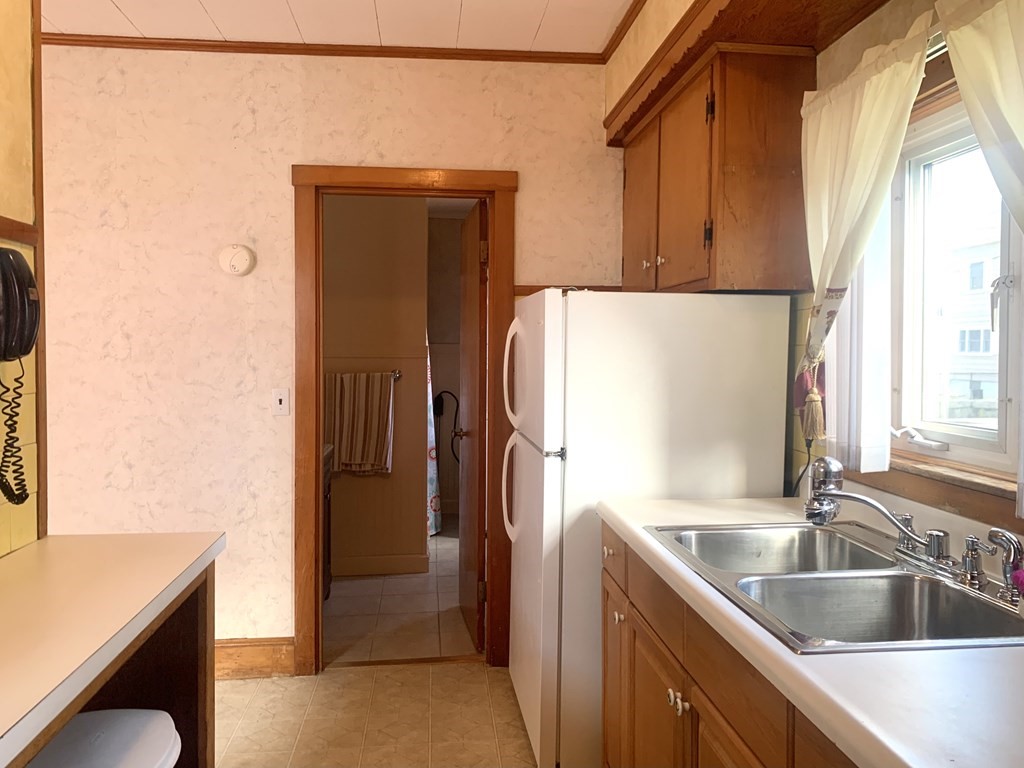 85 Division Street Fall River, MA 02721 - Photo 19 of 42 a kitchen with a refrigerator sink and cabinets