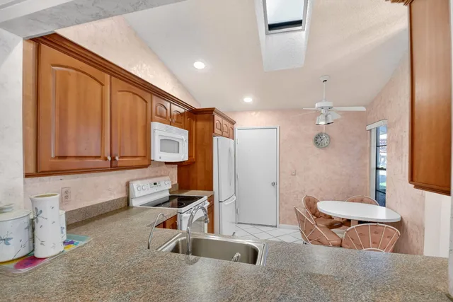 a kitchen with stainless steel appliances granite countertop a refrigerator sink and stove