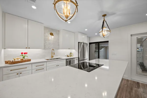 a large kitchen with stainless steel appliances granite countertop a lot of counter space and wooden floors