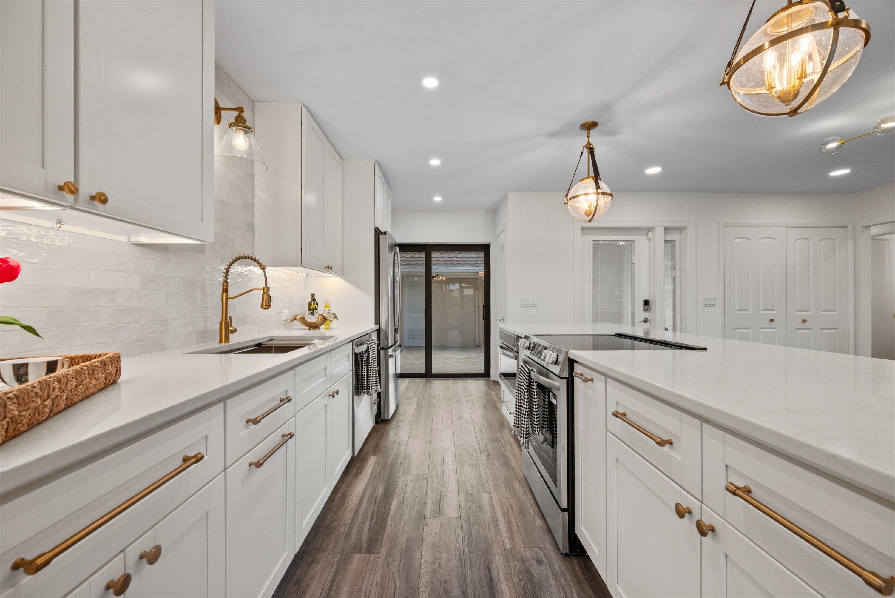 3733 Cape Pointe Circle Jupiter, FL 33477 - Photo 13 of 63 a large kitchen with stainless steel appliances granite countertop a lot of counter space and wooden floors