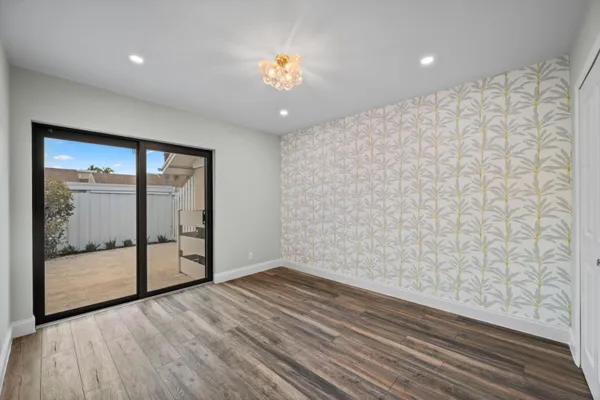 a view of an empty room with wooden floor