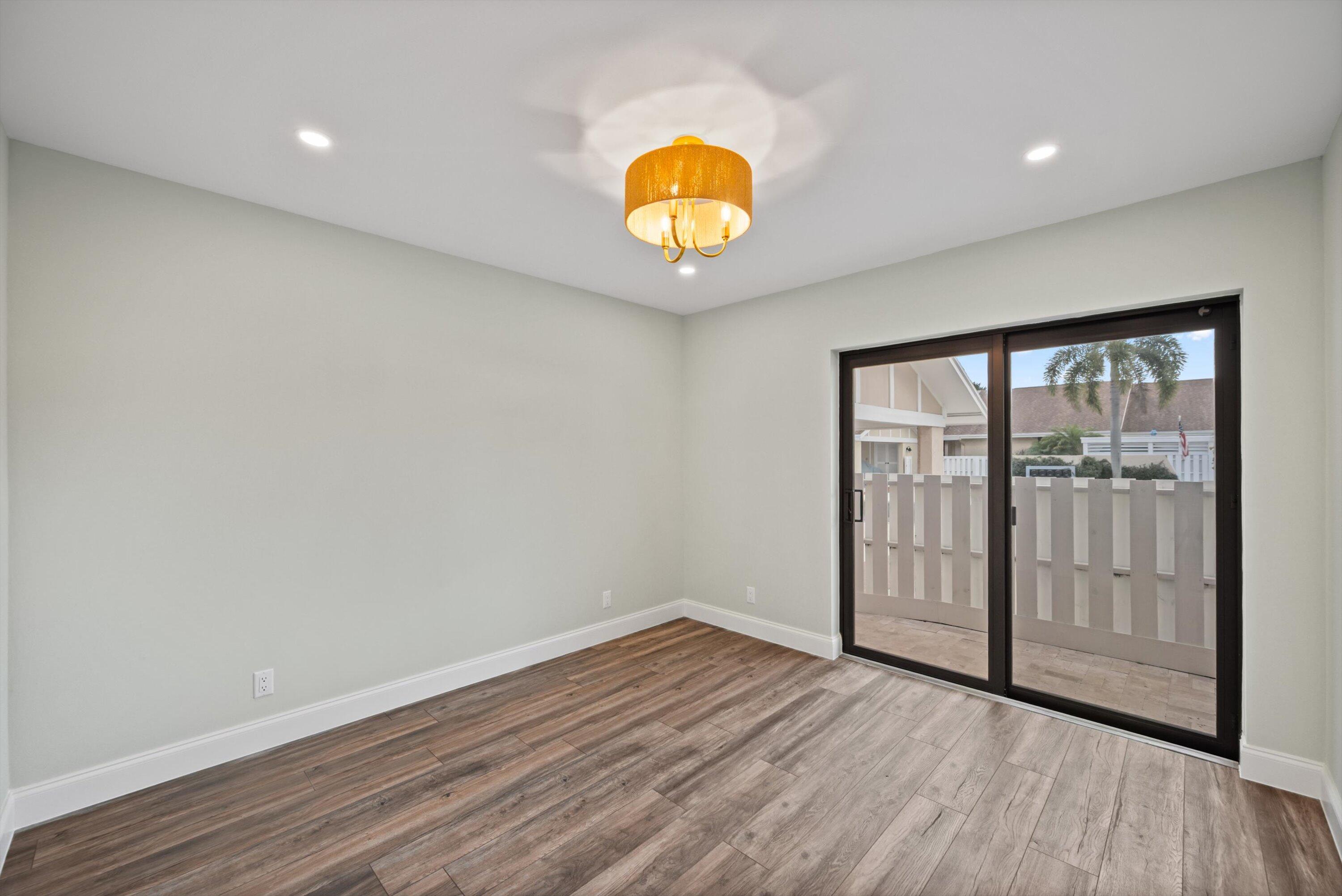 3733 Cape Pointe Circle Jupiter, FL 33477 - Photo 21 of 63 a view of an empty room with wooden floor and a window