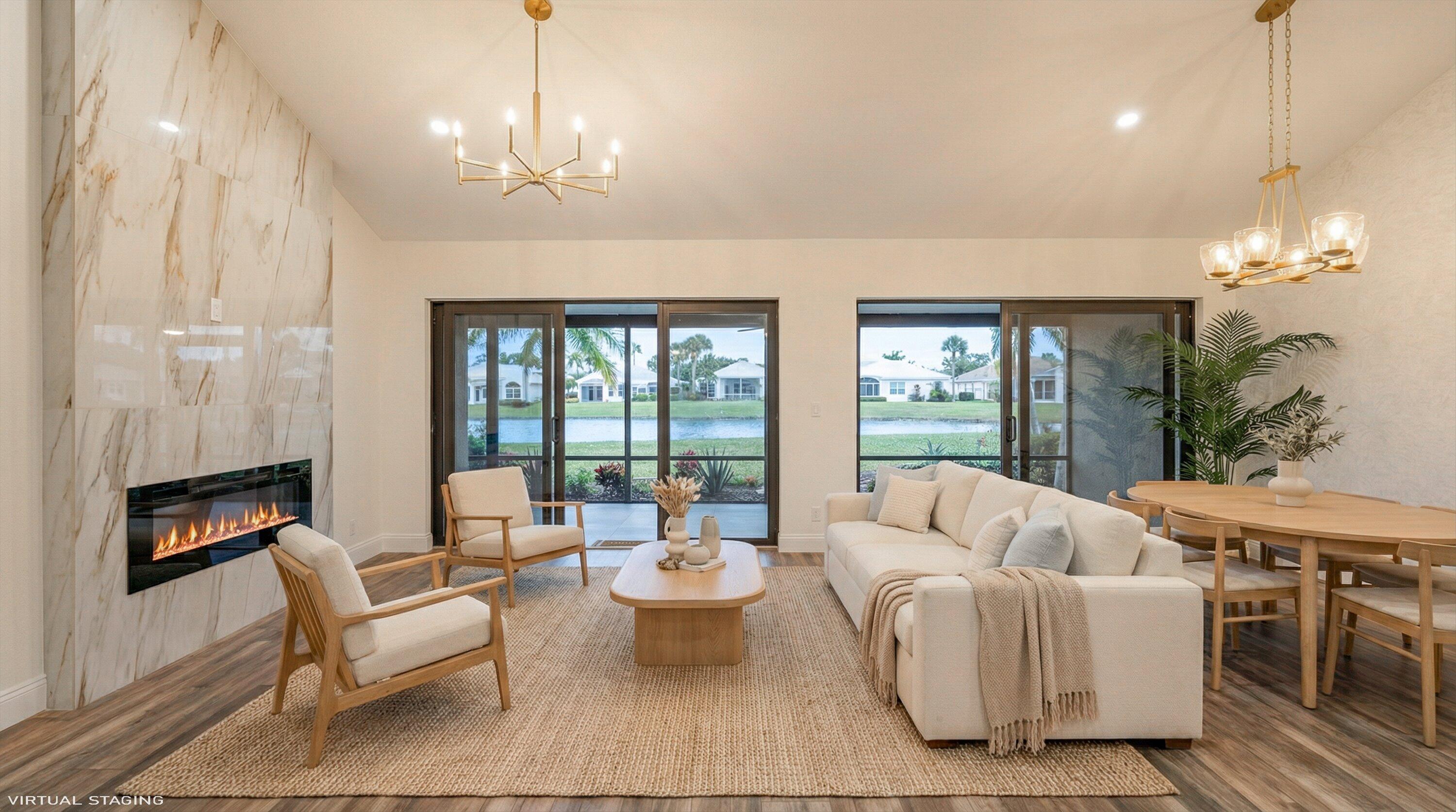 3733 Cape Pointe Circle Jupiter, FL 33477 - Photo 31 of 63 a living room with furniture a chandelier and a large window