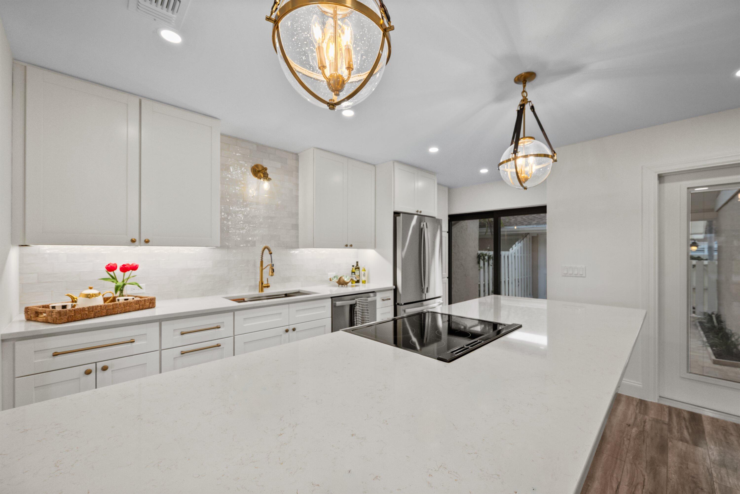 3733 Cape Pointe Circle Jupiter, FL 33477 - Photo 47 of 63 a kitchen with a sink and a stove with wooden floor
