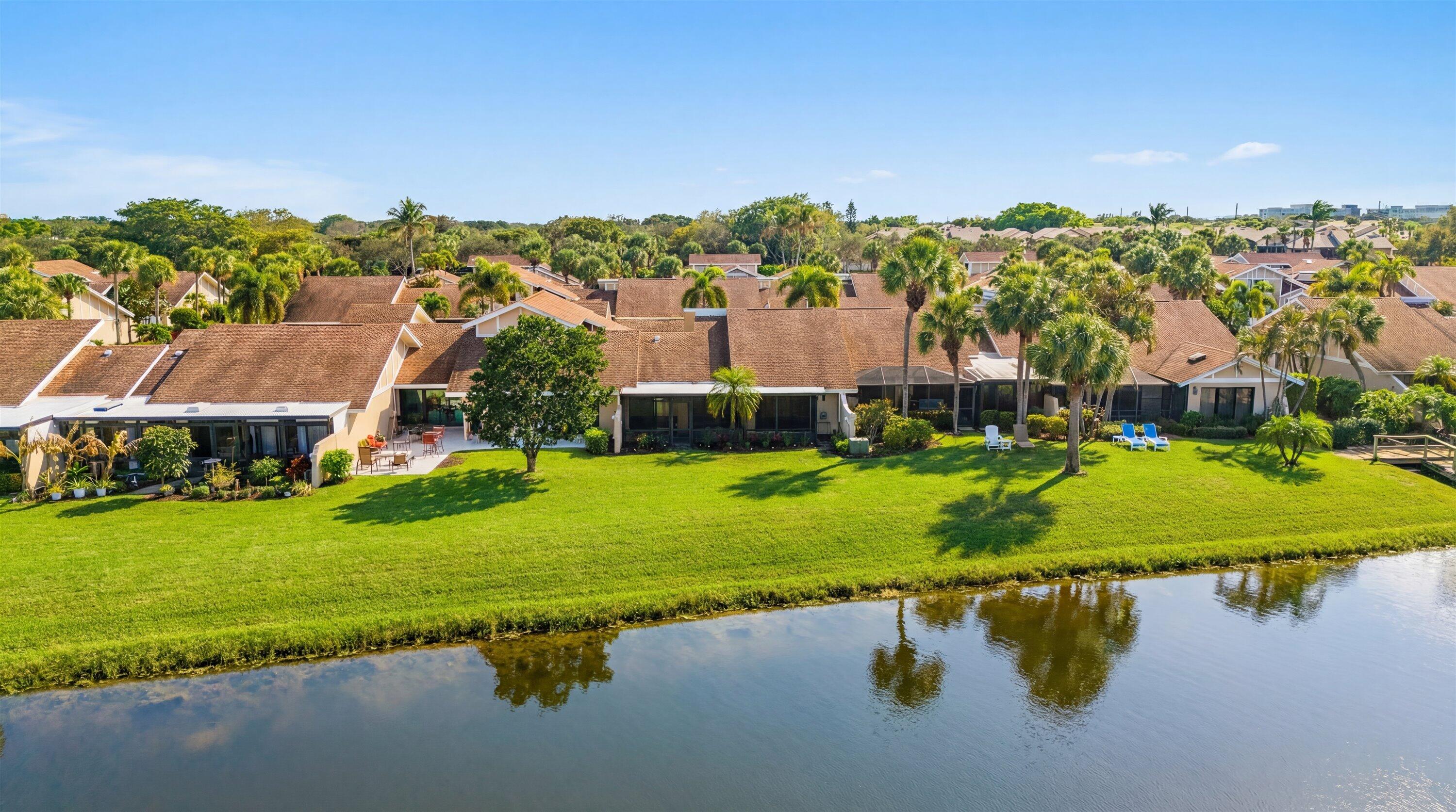 3733 Cape Pointe Circle Jupiter, FL 33477 - Photo 57 of 63 a view of a lake with a garden