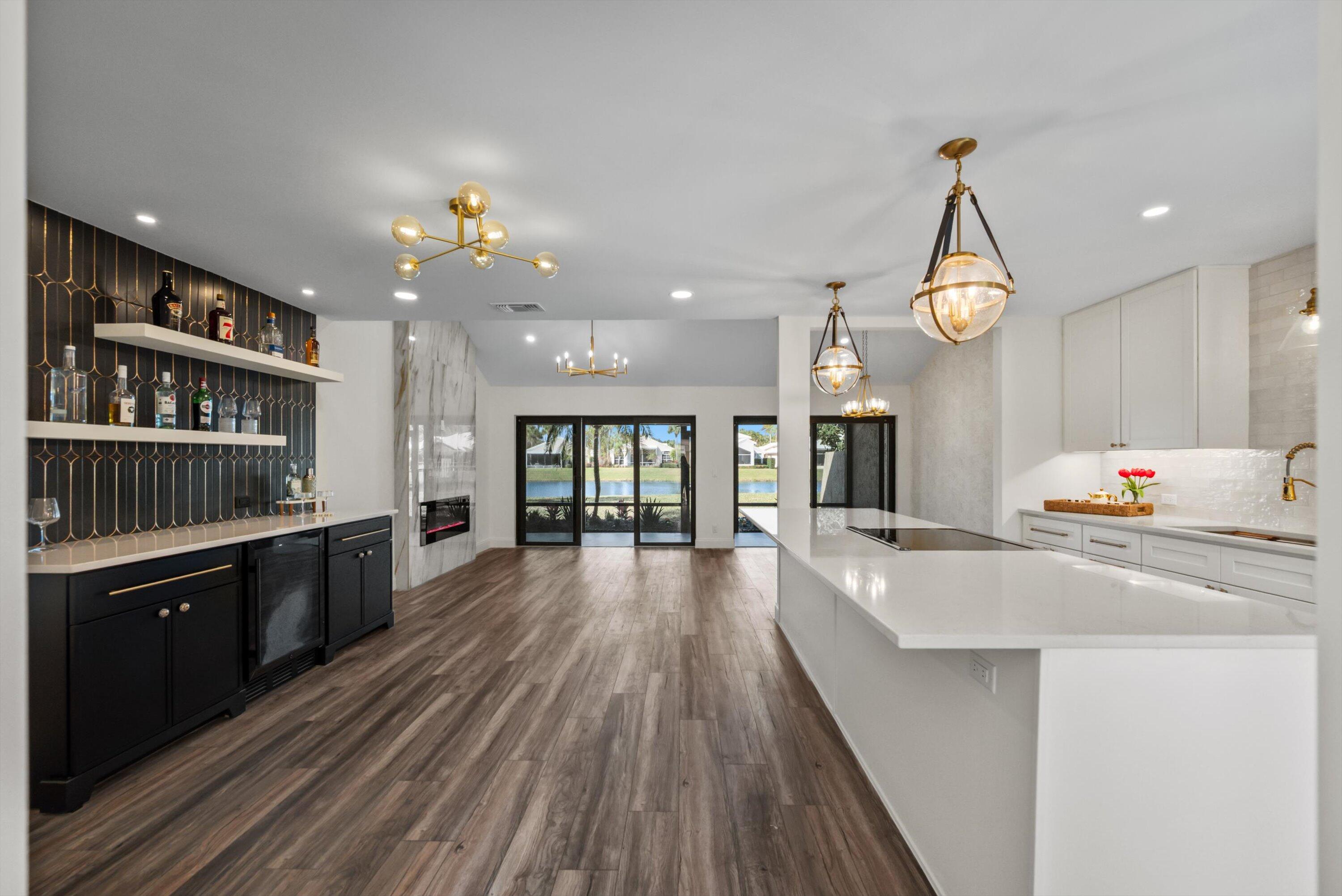 3733 Cape Pointe Circle Jupiter, FL 33477 - Photo 7 of 63 a large kitchen with kitchen island a stove a sink dishwasher and wooden floor