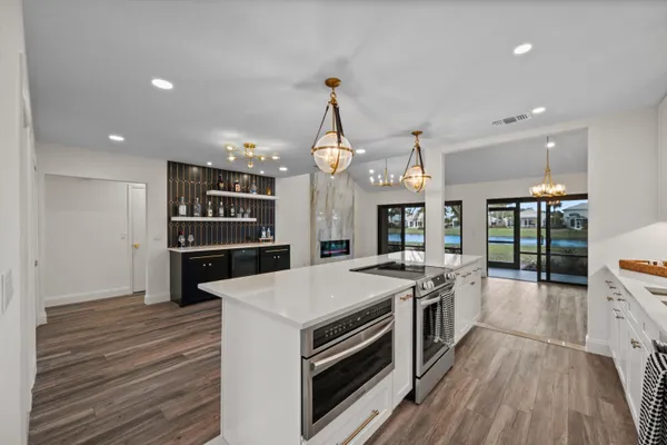 a kitchen with a sink and a stove with wooden floor