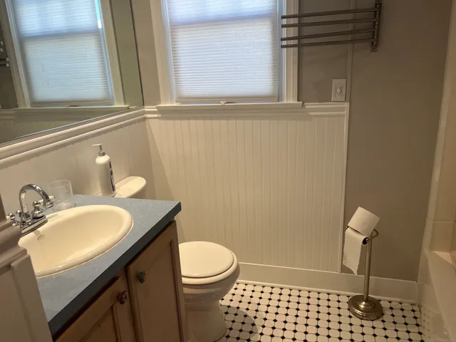a bathroom with a sink a toilet and a window