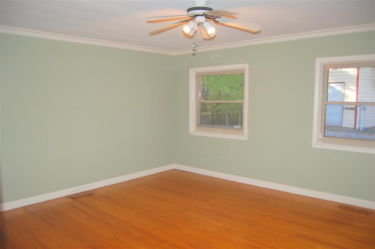 409 Goodwin Road Durham, NC 27712 - Photo 14 of 25 en empty room with wooden floor fan and window