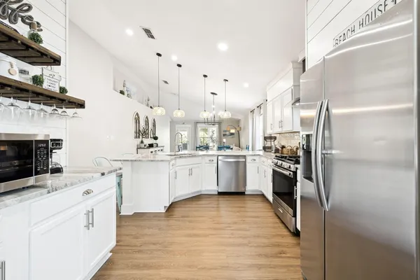 a kitchen with stainless steel appliances kitchen island granite countertop a stove a sink and a refrigerator