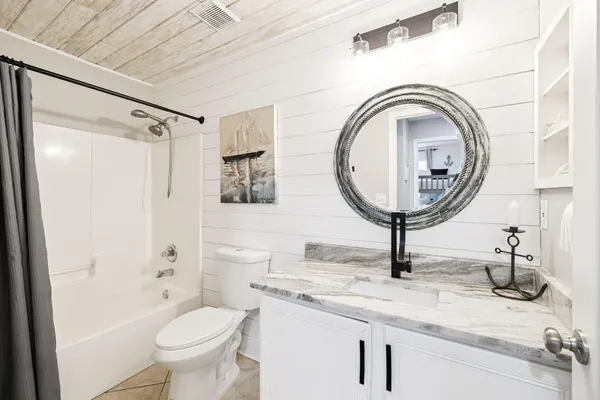 a bathroom with a granite countertop sink a toilet and a mirror