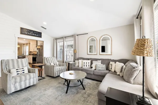 a living room with furniture and a potted plant on table