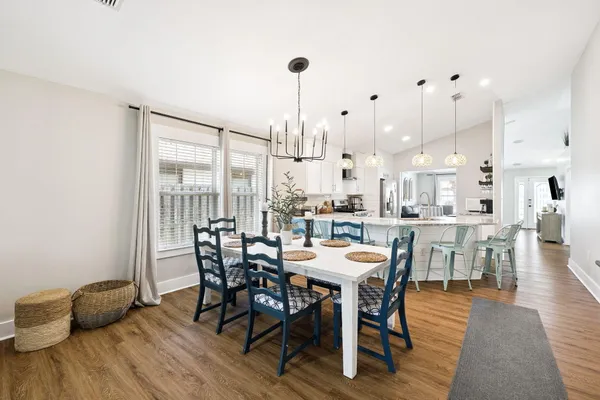 a dining room with furniture a chandelier and wooden floor