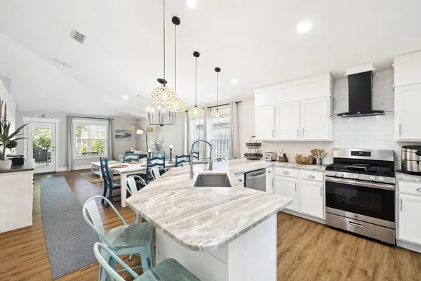 a kitchen with stainless steel appliances granite countertop a stove oven and a white cabinets
