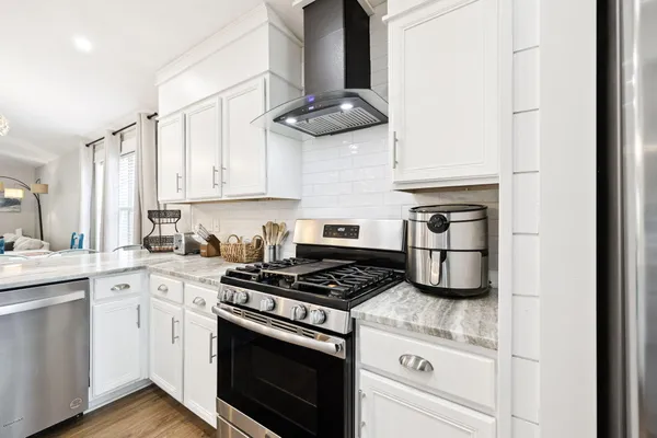 a kitchen with granite countertop white cabinets and white appliances