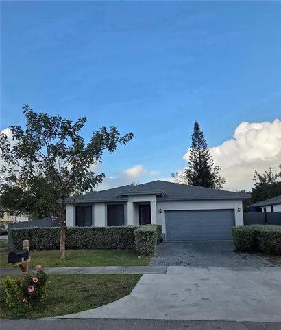 a front view of a house with a garden and yard