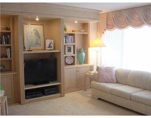 a living room with furniture a flat screen tv and a window