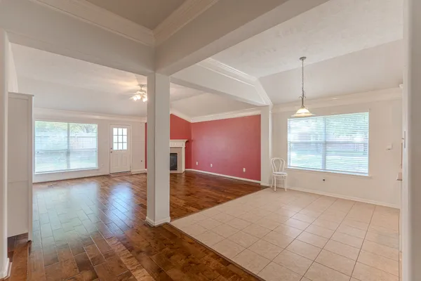 a view of an empty room with a fireplace and a window