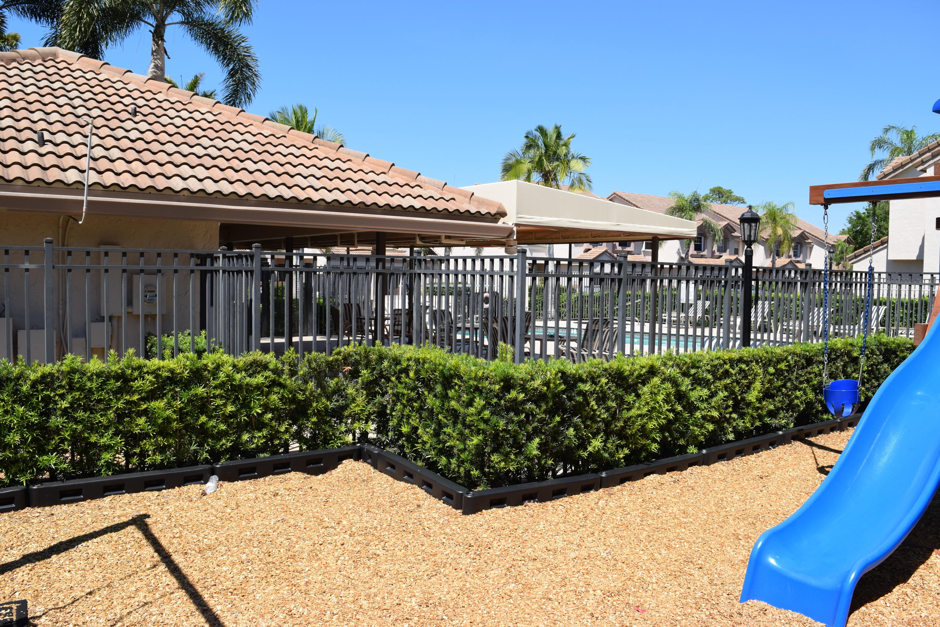 9416 Boca River Circle, Unit 9416 Boca Raton, FL 33434 - Photo 28 of 34 a view of a white house with a flower in a garden