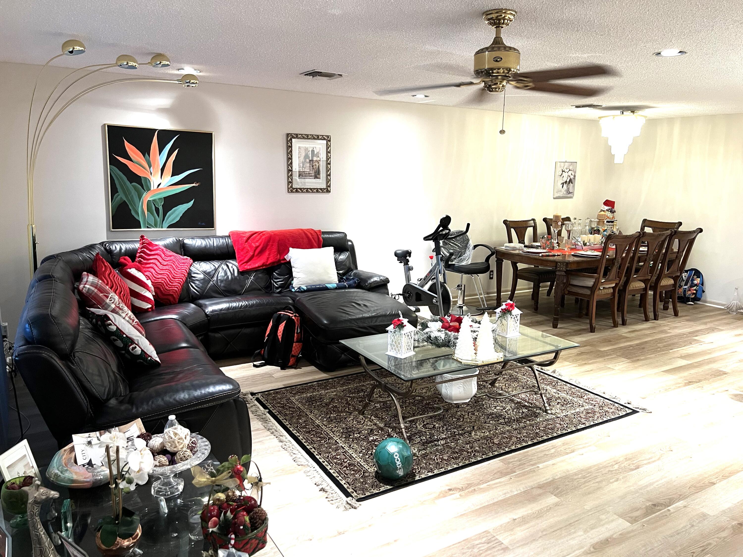 9416 Boca River Circle, Unit 9416 Boca Raton, FL 33434 - Photo 5 of 34 a living room with furniture and a chandelier