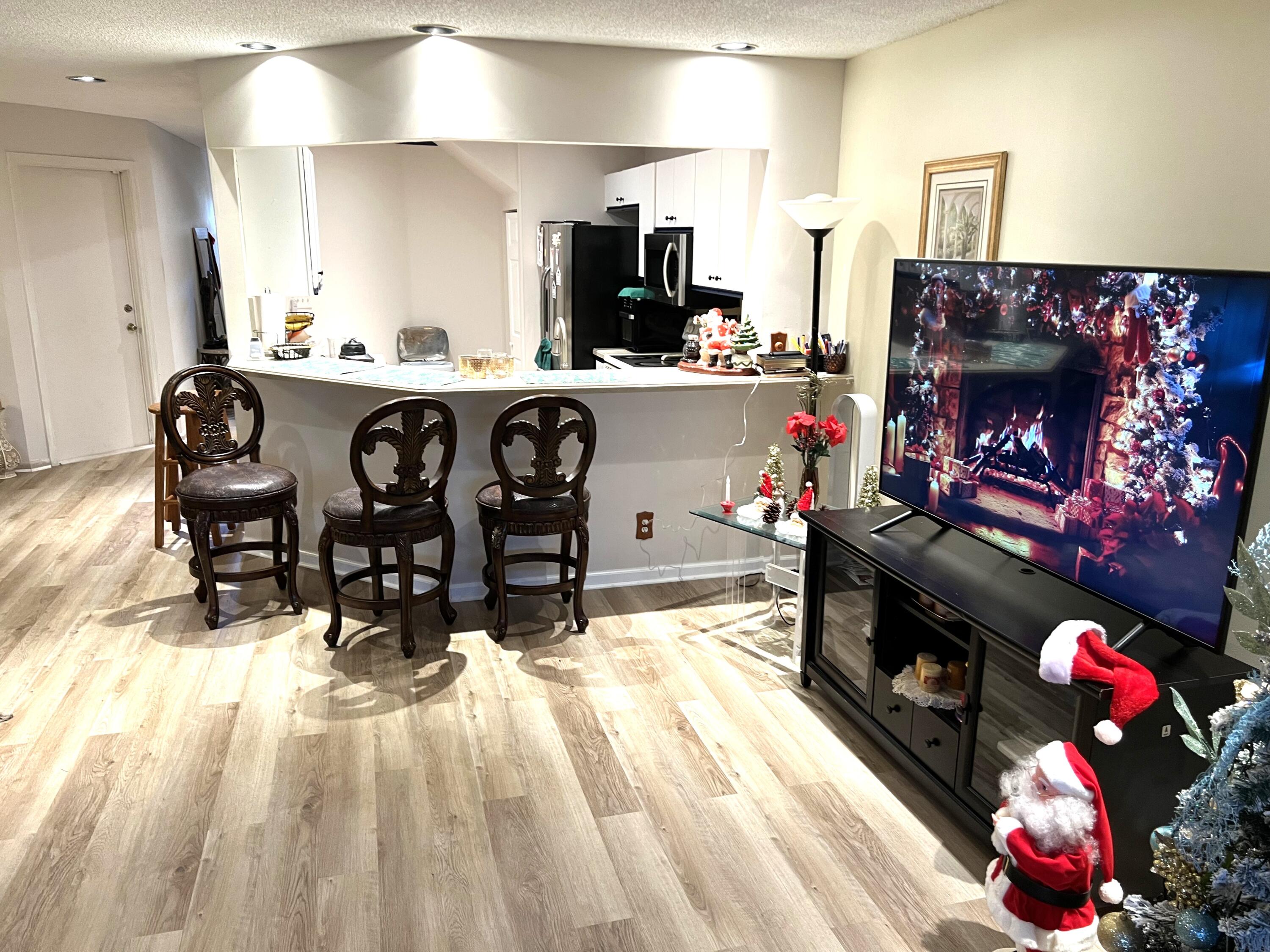 9416 Boca River Circle, Unit 9416 Boca Raton, FL 33434 - Photo 8 of 34 a kitchen with kitchen island granite countertop a stove a sink dishwasher and a fireplace with wooden floor