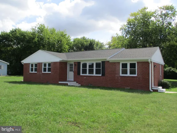 a front view of a house with a garden and yard