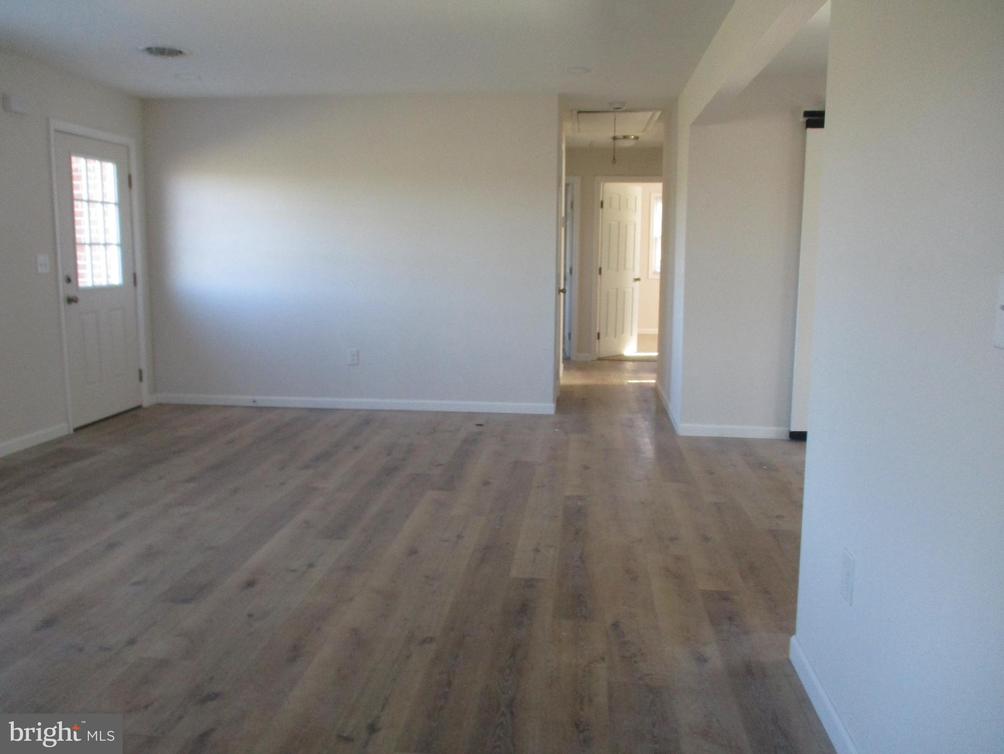 22403 Marsh Creek Road Preston, MD 21655 - Photo 9 of 35 an empty room with wooden floor and windows